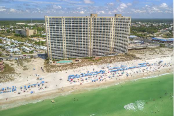 Tall grey building along a sandy beach at Emerald Beach Resort.