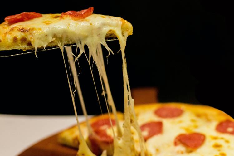 Pepperoni pizza slice being pulled from the pie