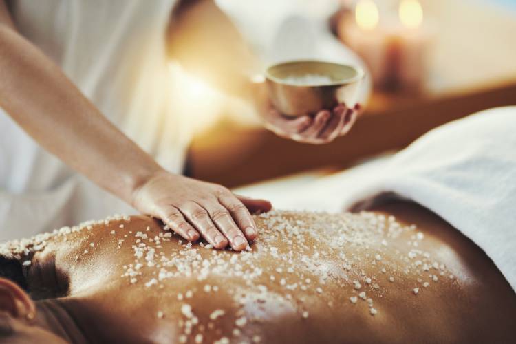 A woman receives a salt scrub massage