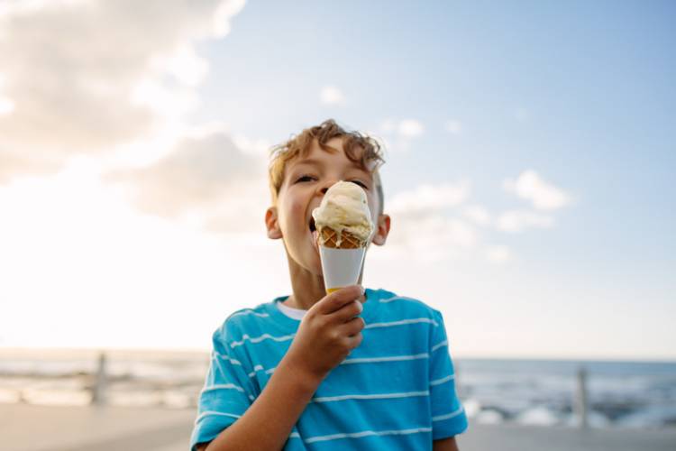 A little boy eats ice cream