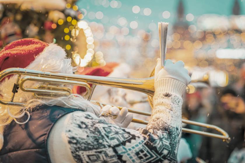 person dressed as Santa playing an instrument in a parade