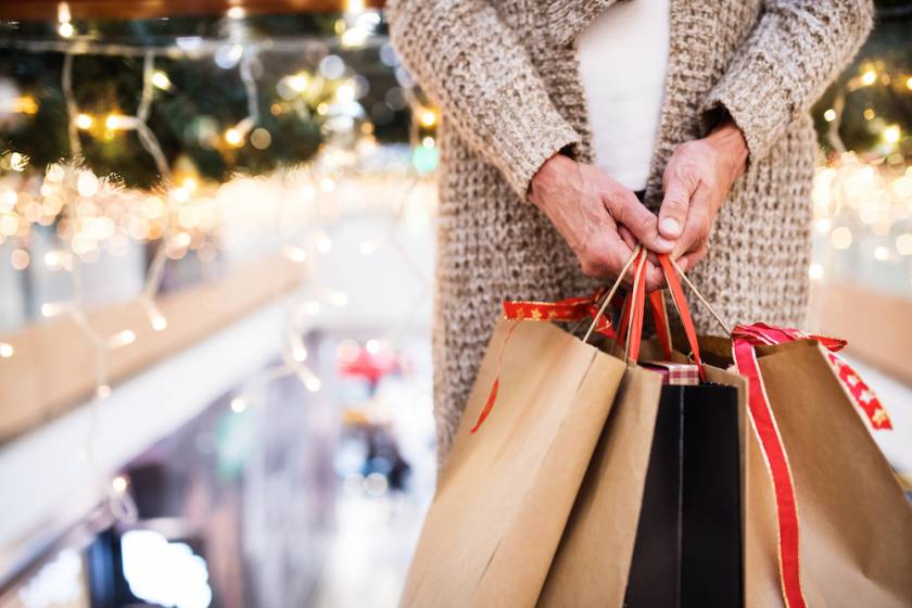woman holding shopping bags with christmas decorations in the background