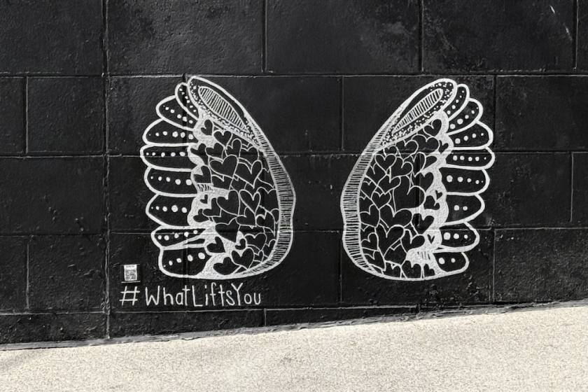 smaller wings mural next to what lifts you mural in the gulch nashville
