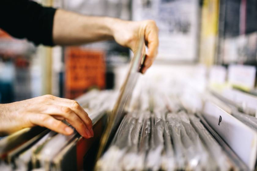 person looking through records at a music store